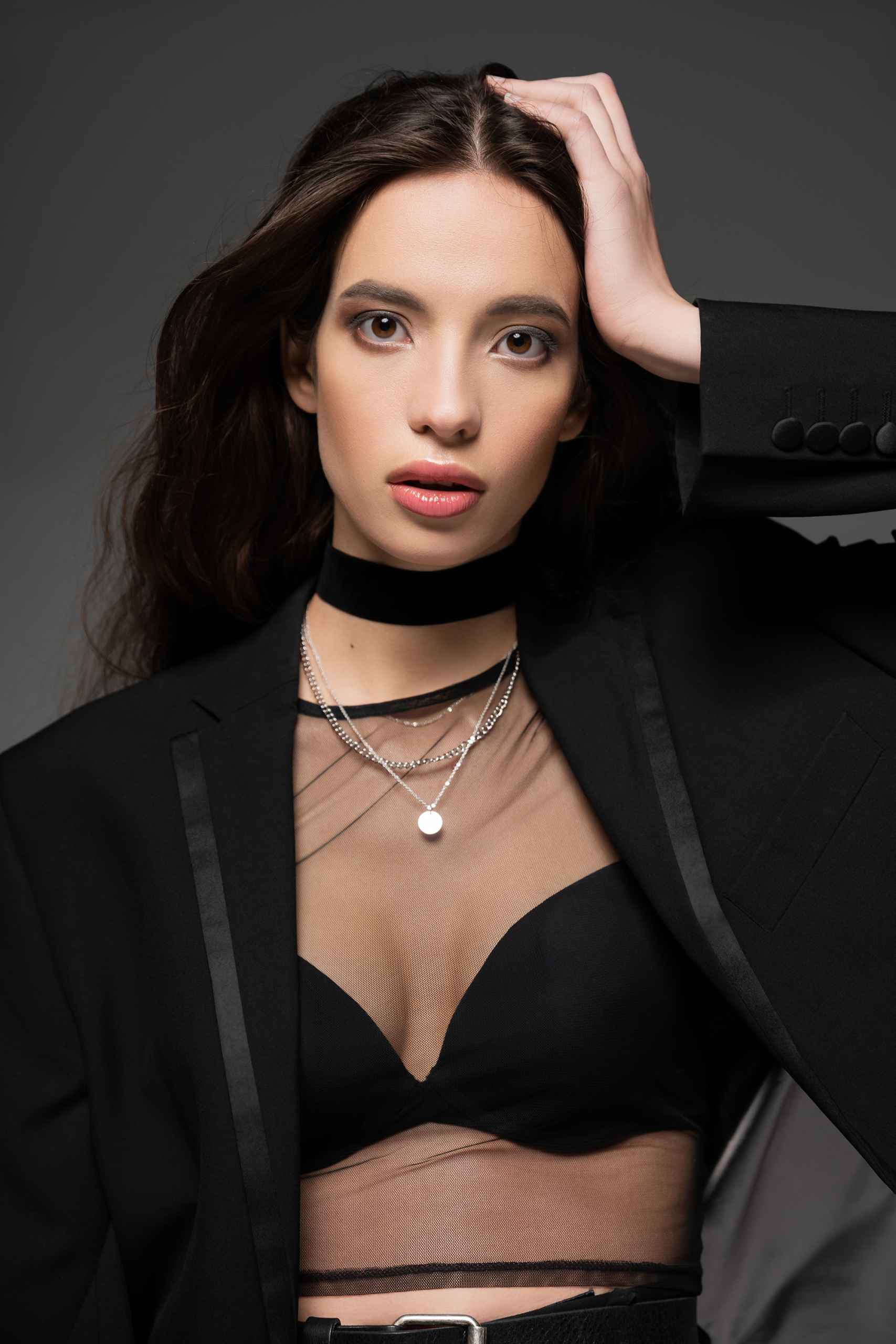 Trendy young asian model posing in black jacket and silver chain